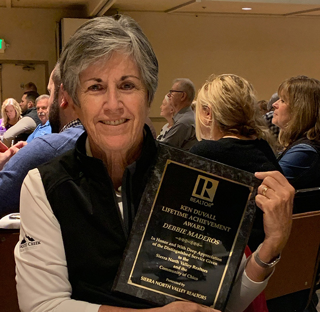 Debbie Maderos holding the lifetime achievement award